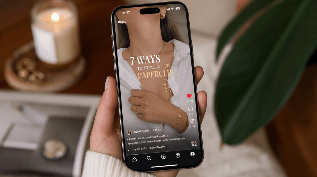 Smartphone screen displaying Instagram Reels or TikTok video of paperclip lookbook, bright fashion content, scrolling mo