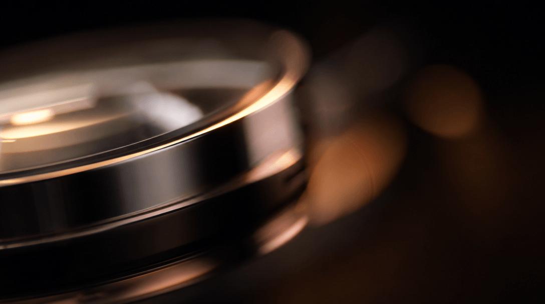 Abstract macro lens photography — extreme close-up of a curved reflective product surface transitioning from razor-sharp