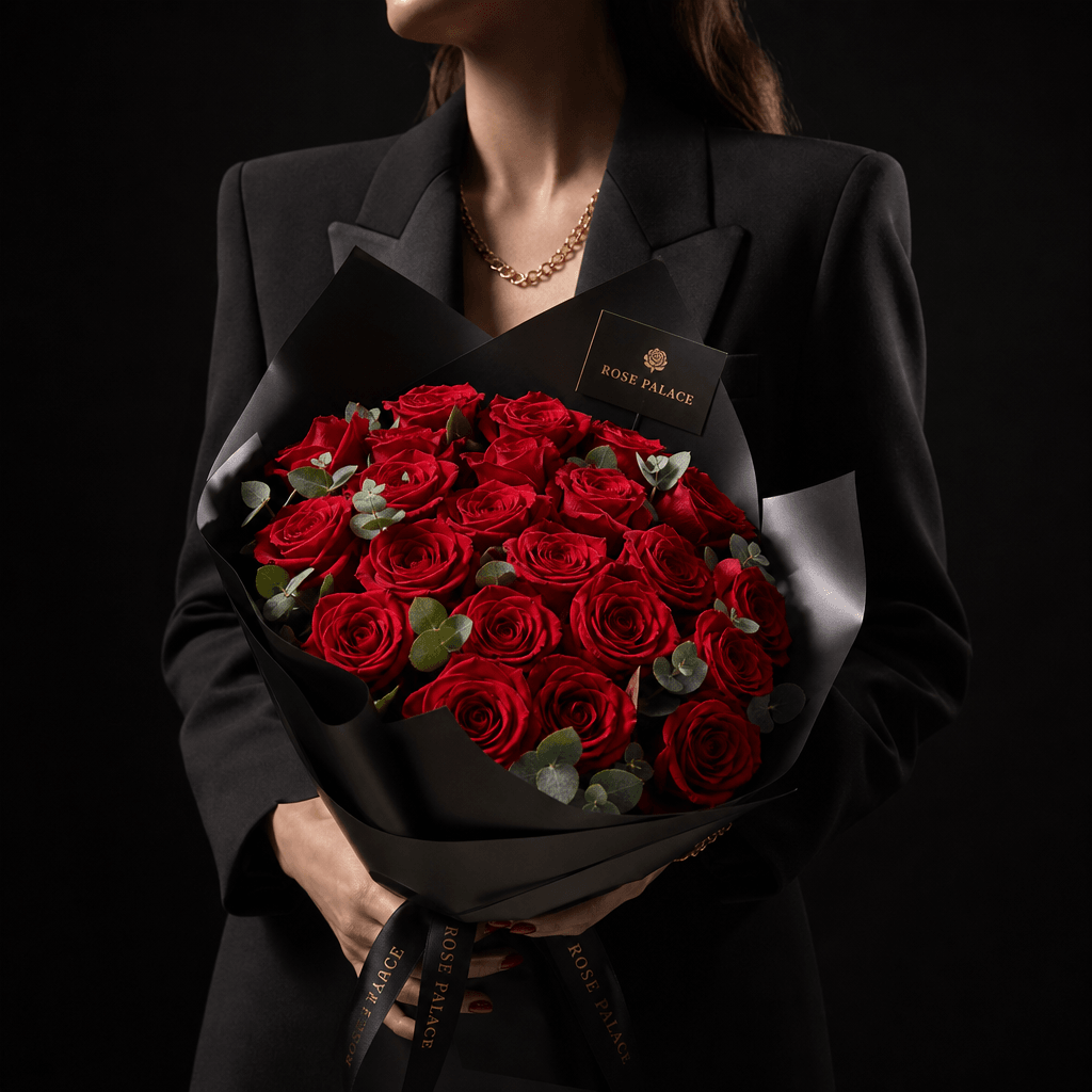 Square luxury flower-shop campaign image featuring a faceless model in a structured black blazer holding a vivid red ros